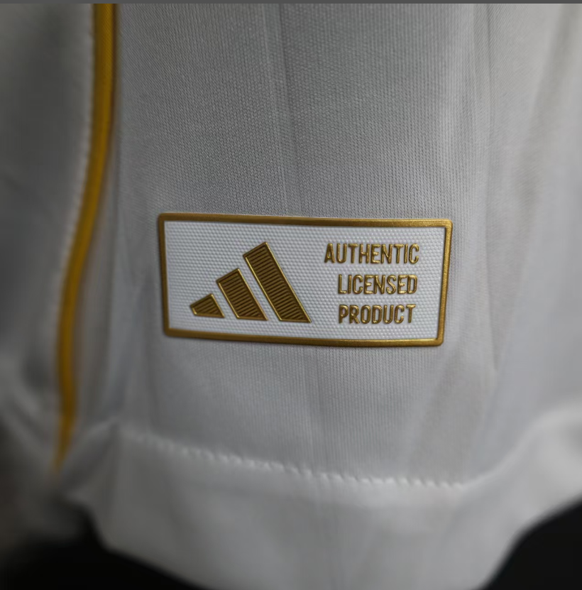 Close-up of the Adidas label reading 'Authentic Licensed Product' on a white jersey.